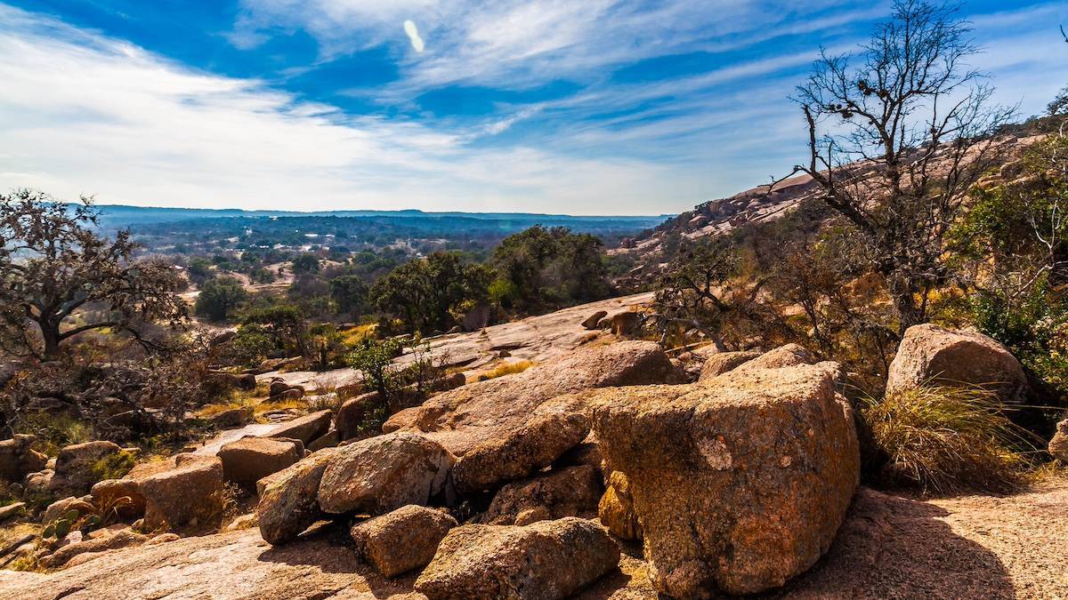 Rocky landscape with sparse trees under a blue sky